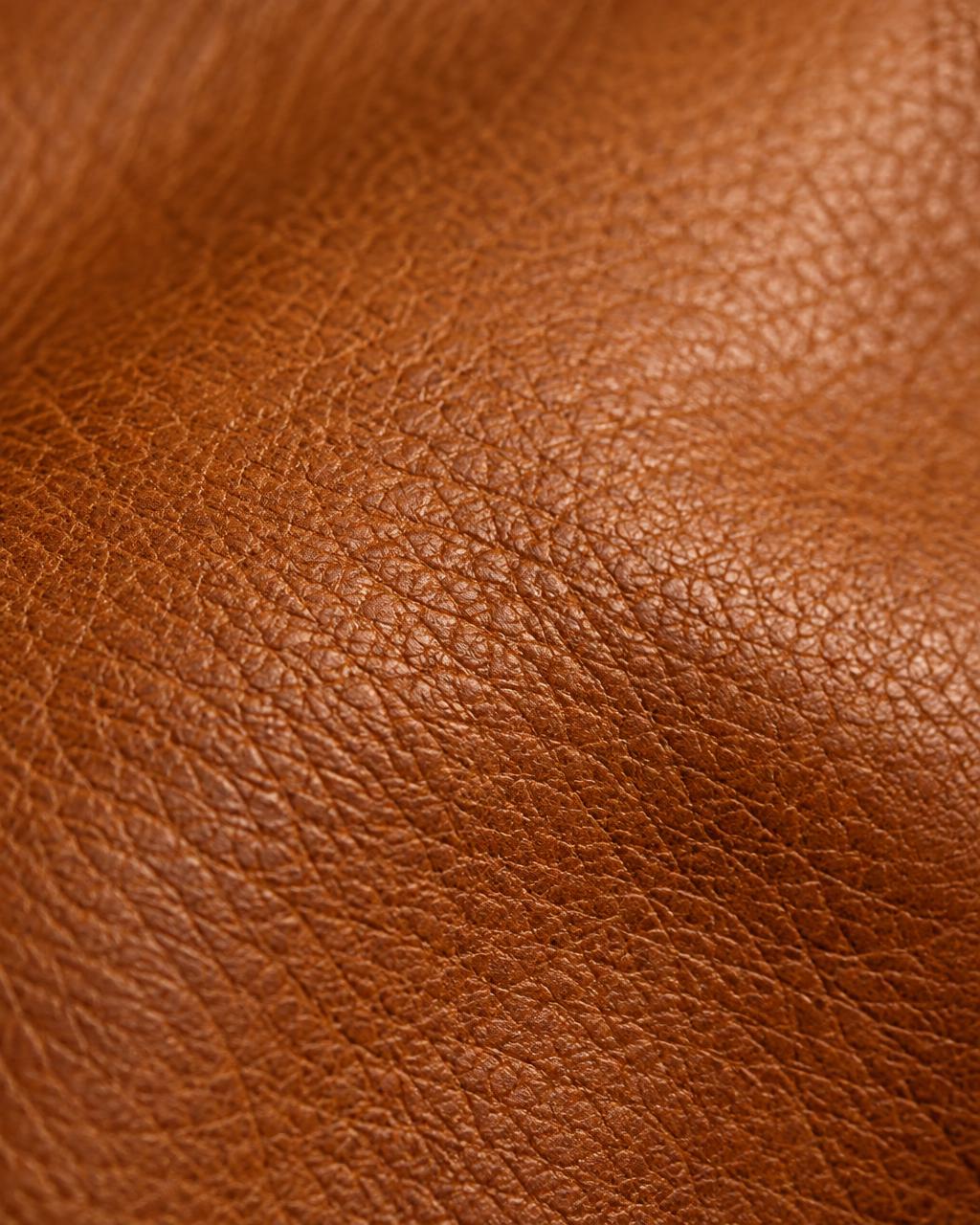 Macro close-up of warm cognac calfskin leather grain